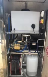 Internal view of the bespoke wheel wash system showing the CAT pump, inlet water tank, chemical setup, and integrated hose reel. Designed for reliability, ease of maintenance, and a clean, organised layout within the stainless steel cabinet.